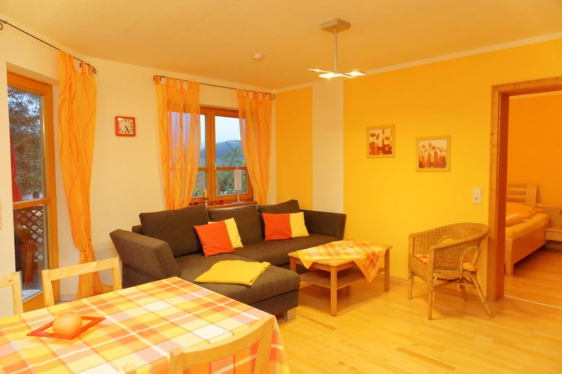 Wohnzimmer mit Sofa und Essbereich