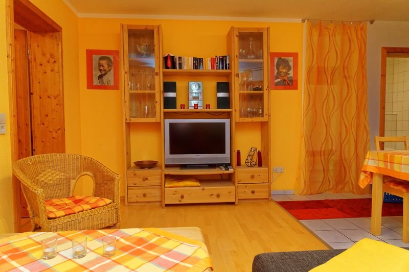 Wohnzimmer mit Fernseher und Sitzecke